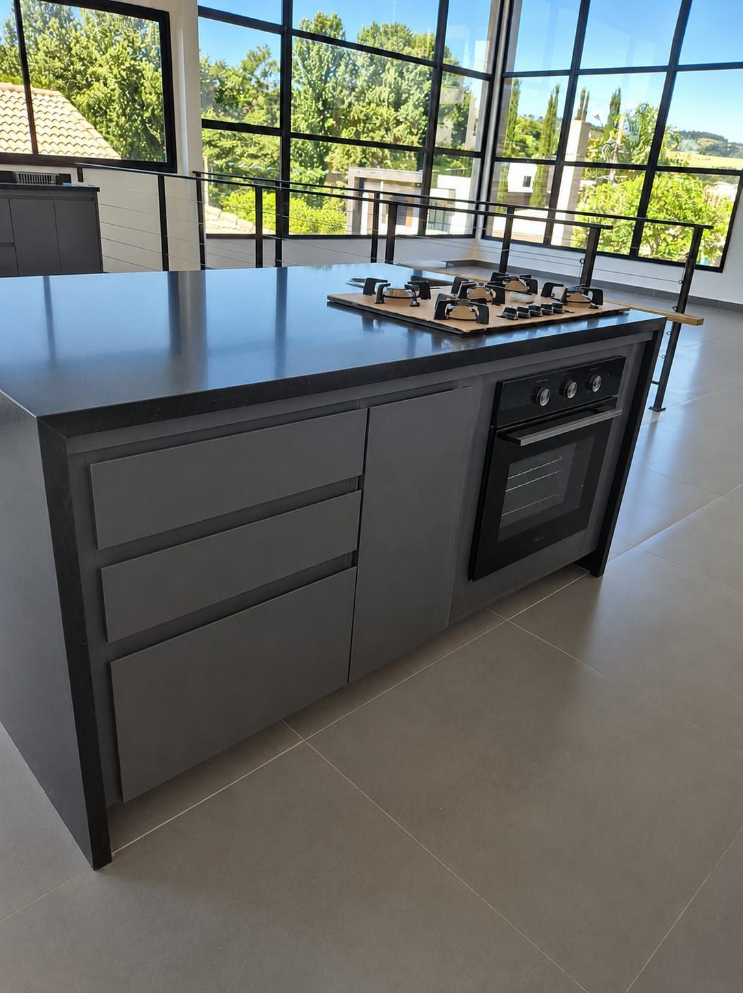 Cozinha planejada cinza com ilha gourmet e bancada escura